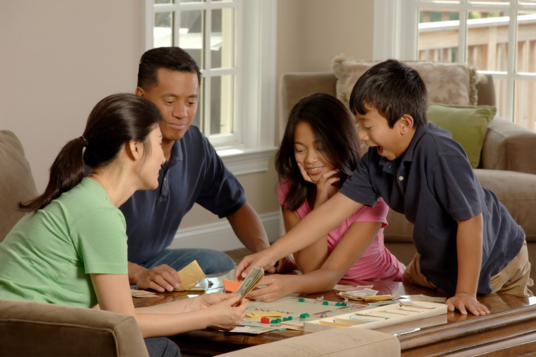 famille avec deux enfants jouant à un jeu de société